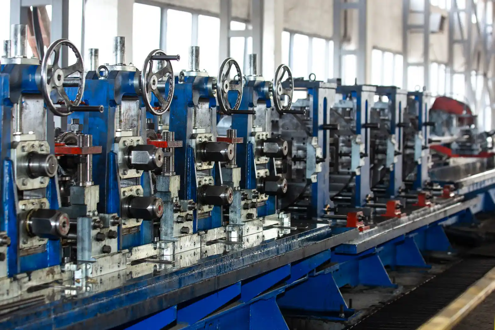 Linha industrial com tubulações e válvulas em bancada de laboratório, usada para medir viscosidade e índice de viscosidade de fluidos, com equipamentos em série ao fundo.